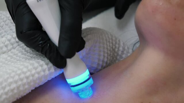 Vacuum cleaning and polishing neck skin of unrecognizable woman in cosmetology clinic, closeup. Professional moisturizing and rejuvenating hardware procedures. Non surgery cosmetology skincare