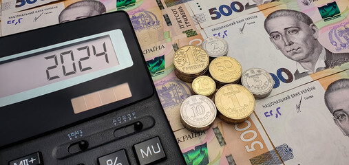 War and crisis. New year 2024 in Ukraine. Calculator on the background of Ukrainian hryvnia...