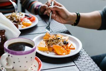Mujeres desayunando fruta con yogurt y granola 