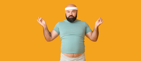 Overweight man practicing yoga on yellow background. Weight loss concept
