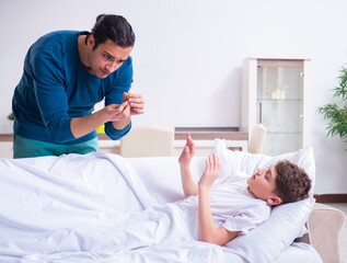 Fototapeta premium Young father caring for sick son