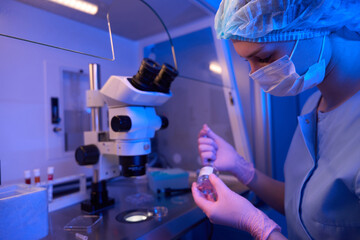 Focused researcher preparing for microscopic examination of biological specimens
