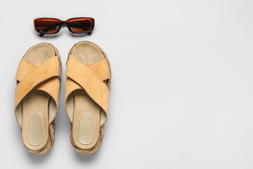 Stylish beige sandals and sunglasses on grey background