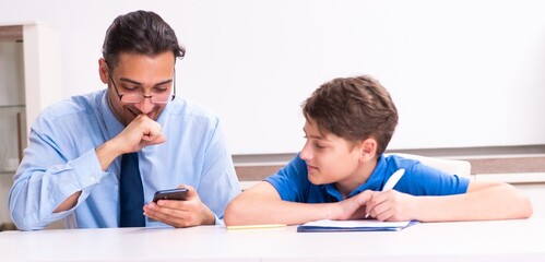 Fototapeta premium Busy father helping his son to prepare for exam