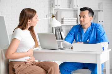 Obraz premium Young pregnant woman visiting doctor in clinic