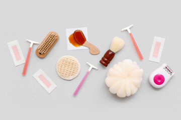 Different supplies for hair removal with sponge and brushes on grey background