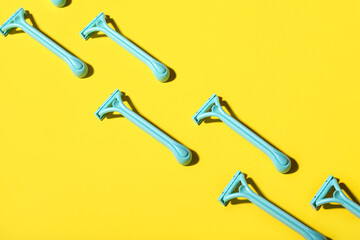Many safety razors on yellow background