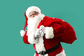 Santa Claus with bag full of Christmas gifts on turquoise background