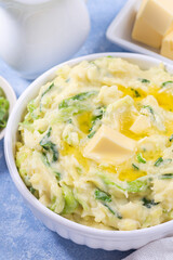 Traditional homemade Irish dish Colcannon or mashed potato with green cabbage and butter, vertical
