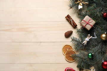 Beautiful fir branches with Christmas decorations on beige wooden background
