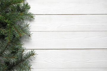 Beautiful Christmas tree branches on white wooden background