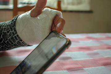 old person with a cast wrist - obrazy, fototapety, plakaty