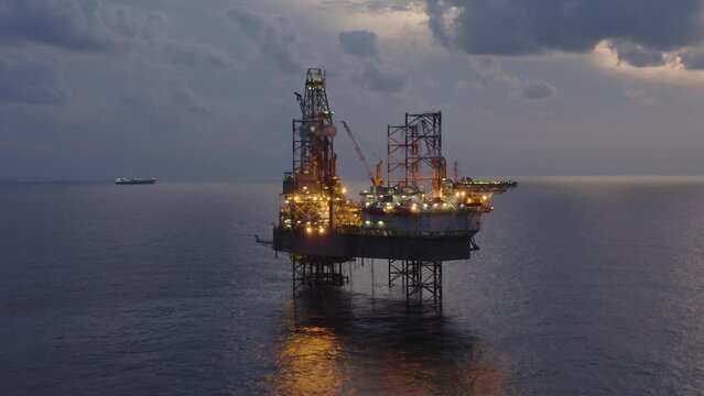 Aerial view of offshore jack up drilling rig during early night time - oil and gas industry
