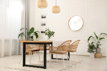 Stylish dining room with cozy furniture, mirror and plants