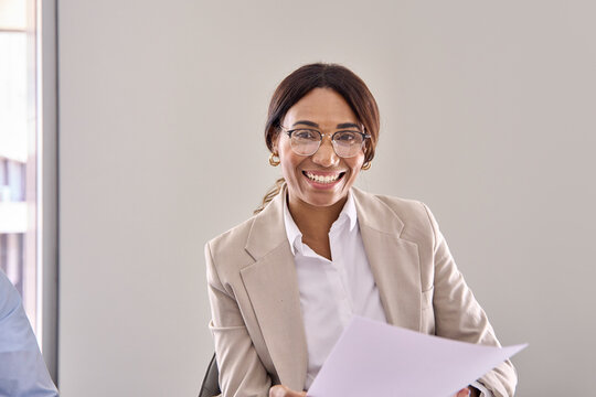 Smiling African American business woman hr manager, lawyer or attorney wearing suit holding documents consulting bank client during legal advice, communicating with recruit at interview meeting.