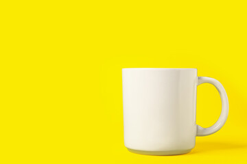One white ceramic mug on yellow background, space for text