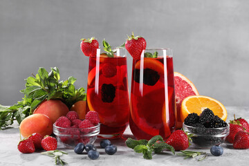 Delicious refreshing sangria with fresh fruits and berries on light grey table