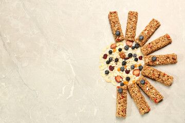 Tasty granola bars and ingredients on beige marble table, flat lay. Space for text