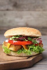 Delicious burger with tofu and fresh vegetables on wooden table