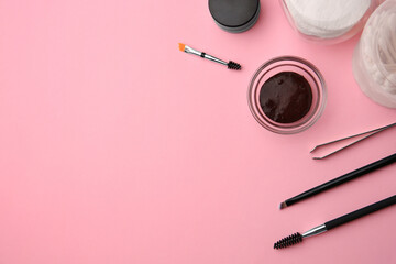 Flat lay composition with eyebrow henna and professional tools on pink background, space for text