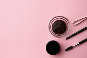 Flat lay composition with eyebrow henna and professional tools on pink background, space for text