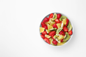 Yummy fruit salad in bowl on white background, top view. Space for text