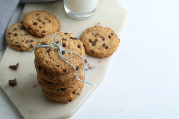 Tasty chocolate chip cookies on white wooden table, closeup. Space for text