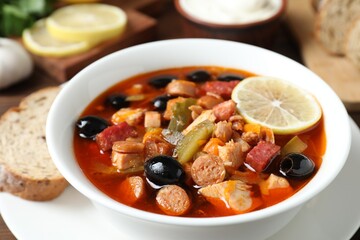 Meat solyanka soup with sausages, olives and vegetables on table, closeup