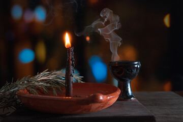 traditional ritual with fire and black candle in clay plate accompanied by pepper, sea salt, herbs...