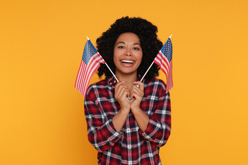 4th of July - Independence Day of USA. Happy woman with American flags on yellow background