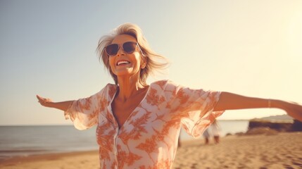happy senior woman in sunglasses having fun on beach at beautiful summer day