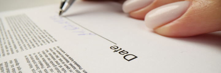 Woman writes date above line after signing contract papers