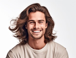 Young man with wavy long hair and a broad smile, dressed in a neutral beige shirt. Ideal for projects on contemporary fashion, hair care, or capturing radiant youthfulness.
