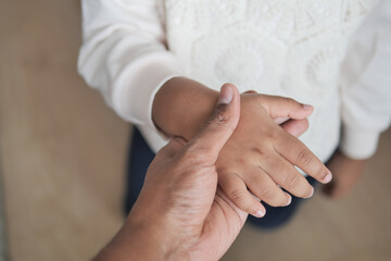 father holding hand of baby child, close up .