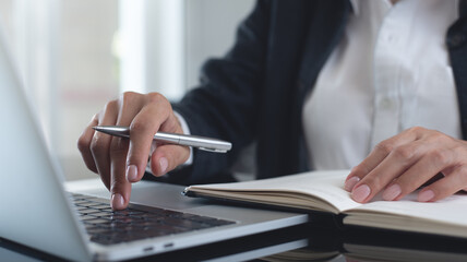 Business woman working on laptop computer, planning work project and searching the information at...