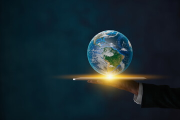 Fototapeta premium Businessman Hold Tablet and Globe or World Trade Technology Concept in Dark Tone