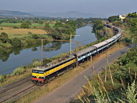 Kamshet, Maharashtra, India-November 21st, 2014:Express passenger train passing parallel to river Indrayani in Kamshet.