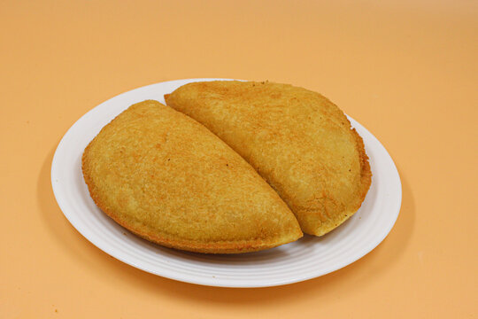 Brazilian chicken croquettes on white plate with orange background