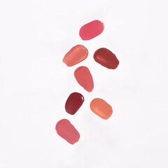 Shades of lipstick different tones color stroke on white background. Lipstick smear smudge swatch isolated on white background. Cream makeup texture.