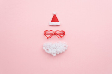 Santa hat, beard and glasses on color background top view
