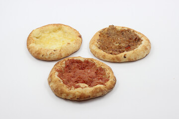 Assorted Brazilian mini esfihas on white background