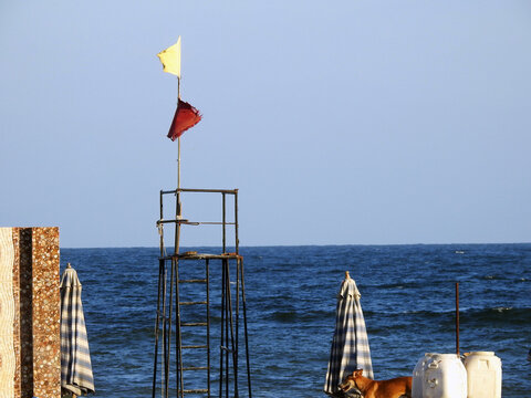 Yellow and red flags on the beach, beach warning flag system, red flag means High risk, rough conditions, strong surf, and currents, Yellow flag means Medium risk, light surf currents, lifeguard