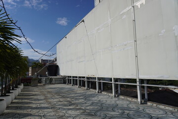 Obraz premium Rooftop Oasis with Modern Architecture: A rooftop patio of contemporary architecture merges seamlessly with the stunning blue sky and cityscape views. Capturing a sense of calm and urban elegance. 