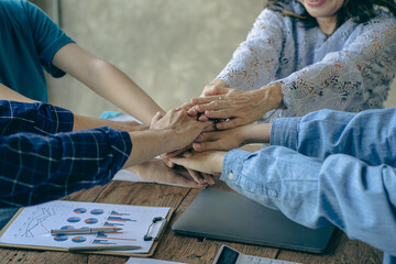 The hands of a team of businessmen joining forces celebrate the concept of unity. A close-up photo of a team working together to make business successful. teamwork business