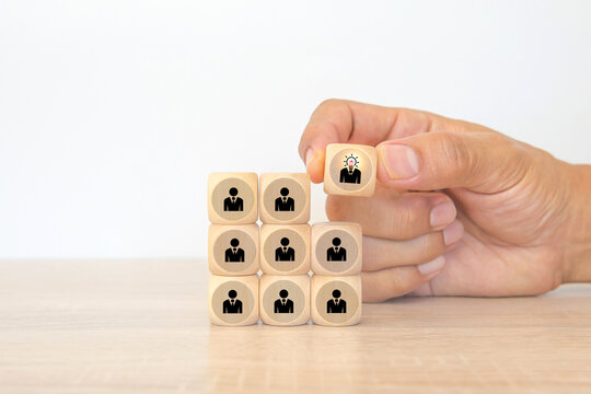 Hand choose cube wooden block stack pyramid with human resources icon for leader or leadership teamwork and organization management personnel target challenge work or candidate.