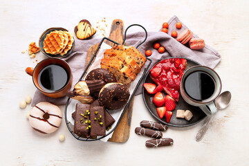 Fototapeta na wymiar Cup of coffee with waffle, cookies, cake and dunut on light background. Hot drink and desserts
