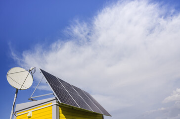 Photovoltaic modules and antenna on the roof of a house
