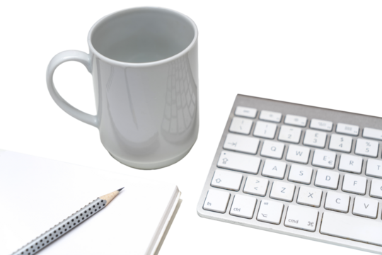 a cup of coffee on the desk, between a keyboard and a clipboard