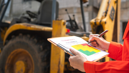 The operation supervisor is using ballpoint pen to marking on the risk assessment matrix form, to...