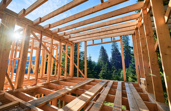 Residential wooden frame structure being erected. Initiation of fresh building endeavor for dwelling or mountain chalet. Concept of contemporary ecological construction and modern architectural style.